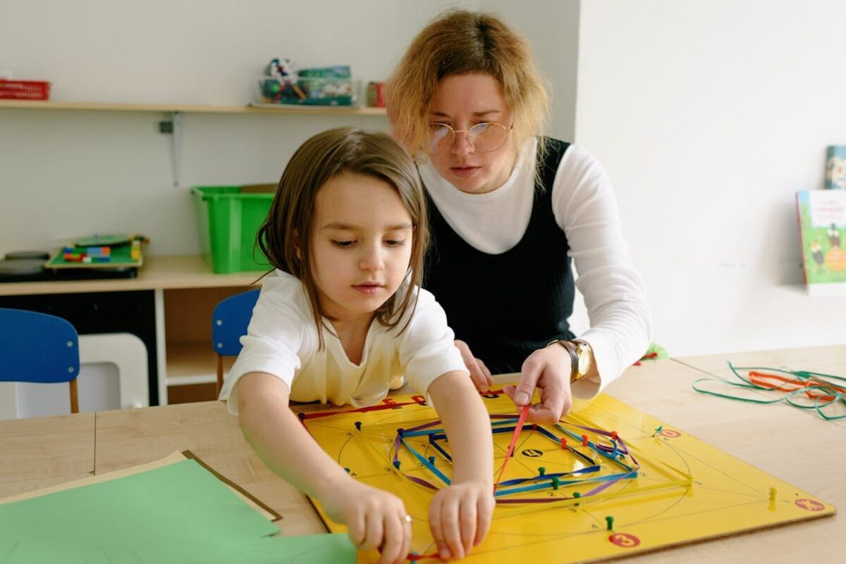 Schulbegleiterin unterstützt Kind beim Lernen