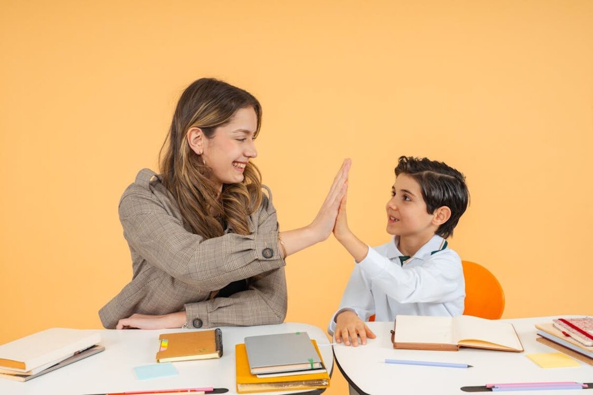 Schulbegleiterin und Kind geben sich High Five